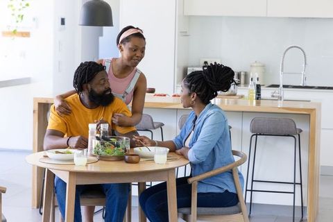 African american family sharing healthy meal and warm embrace at modern kitchen table