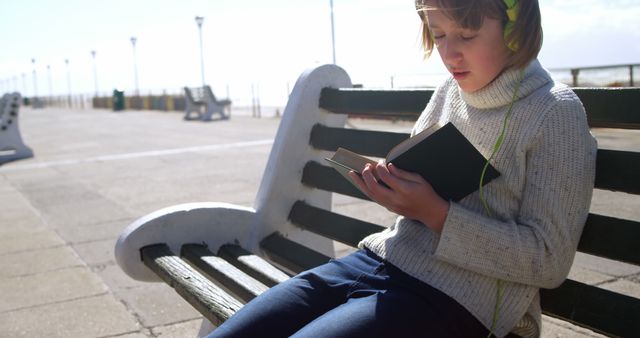 Teenager Reading on Bench with Headphones Outdoors - Download Free Stock Images Pikwizard.com