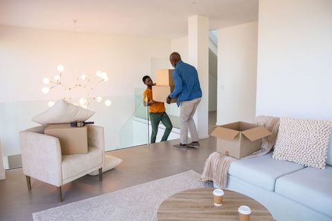 Father and son moving boxes in modern home