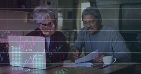 Senior Couple Analyzing Finances at Home with Digital Graphs Overlay