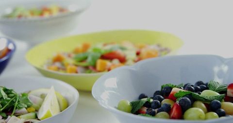 Variety of fresh fruit salads in elegant ceramic bowls