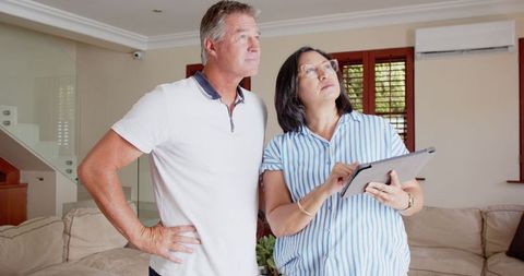Senior couple inspecting home air conditioning