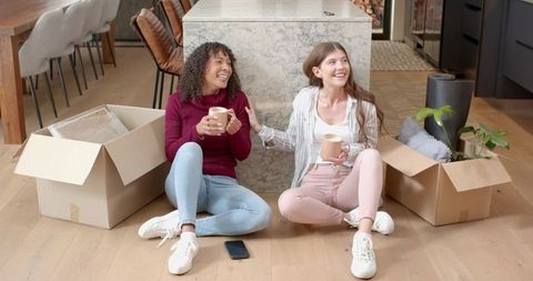 Cozy Unpacking Moment Two Friends Relax with Coffee
