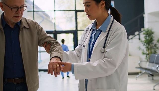 Doctor guiding senior patient through clinic entrance caring medical team assisting