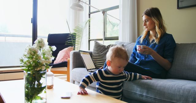 Mother Enjoying Coffee While Babysitting in Cozy Modern Living Room - Download Free Stock Images Pikwizard.com