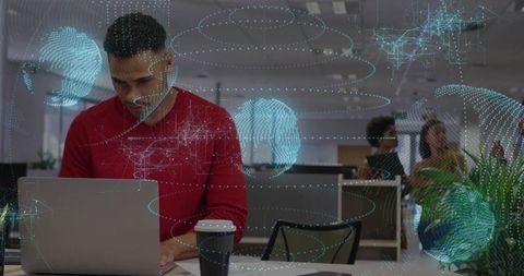 Innovative professional working on laptop in futuristic office with holographic graphics