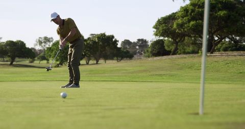 Man Putting in Golf Course on Sunny Day - Download Free Stock Images Pikwizard.com