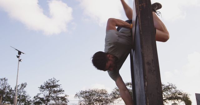 Determined Man Overcoming Obstacle Wall at Outdoor Training - Download Free Stock Images Pikwizard.com