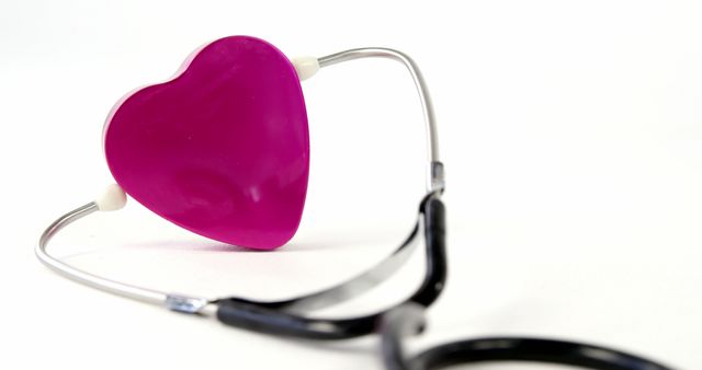A pink heart-shaped object is connected to a stethoscope against a white background, with copy space. It symbolizes the concept of healthcare with a focus on love and compassion in the medical field.