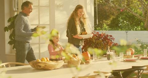 Family Gathering Around Sunlit Rustic Backyard Table Serving Bread and Smiles