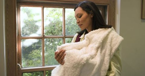 Asian Woman Embracing White Fleece Blanket by Sunny Window