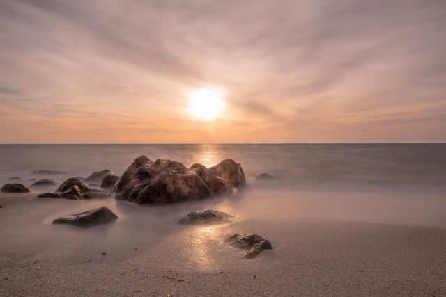 Peaceful Sunrise Over Rocky Beach - Download Free Stock Photos Pikwizard.com