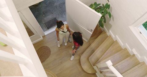 Female Friends Greeting in Bright Home Entryway