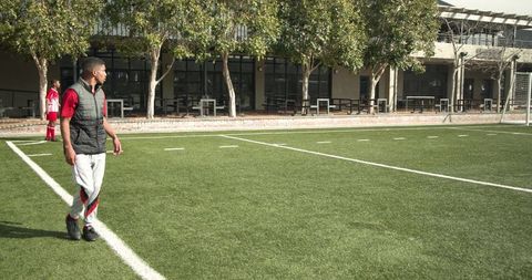 Young Boy Playing Soccer on a School Field Outdoors