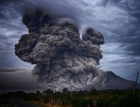 Powerful volcanic eruption with ash plume under dark skies