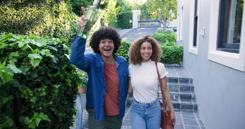 Excited Friends Arriving with Wine for a Celebration