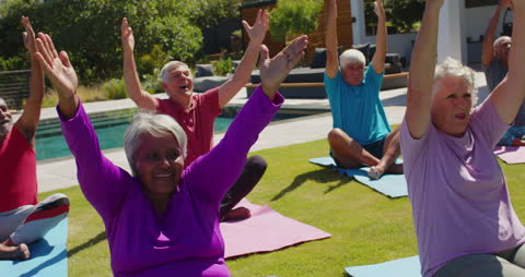 Senior Group Enjoying Outdoor Yoga Session in Sunny Garden