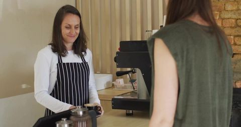Friendly Barista Serving Coffee in Cozy Café