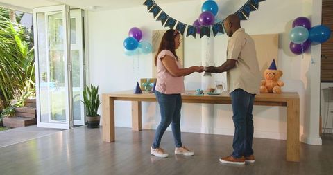 Joyful Couple Celebrating Birthday at Home with Cake and Decorations