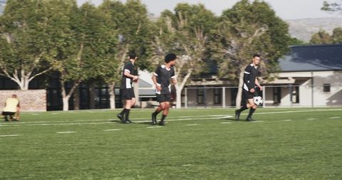 Teen soccer players practicing teamwork on sunny field