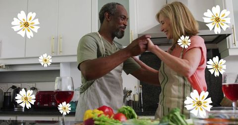 Senior Diverse Couple Dancing in Kitchen Amidst Fresh Produce