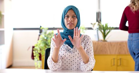 Businesswoman in Hijab Making Video Call in Office