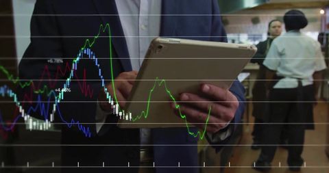 Businessman Analyzing Financial Data on Tablet in Professional Setting