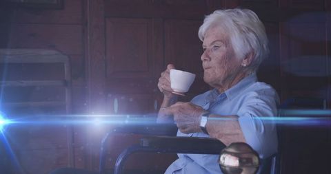 Senior Woman Enjoying Tea in Wheelchair with Lens Flare Effect