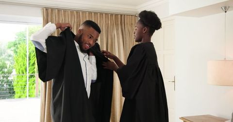 African American Couple Preparing for Graduation Ceremony at Home