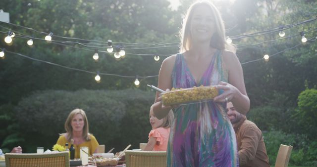 Woman Carrying Dish at Outdoor Backyard Party - Download Free Stock Images Pikwizard.com