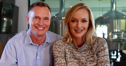 Smiling Middle-Aged Man and Woman Business Colleagues at Work