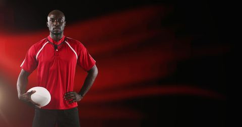 Rugby player in vibrant red sports attire holding ball