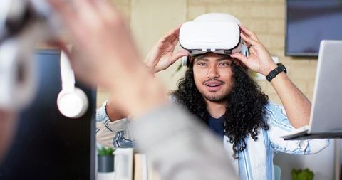 Professional testing white vr headset while collaborating in modern office