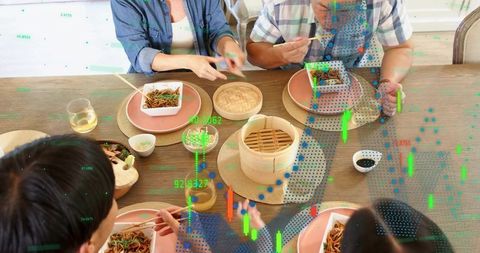 Family sharing asian noodle meal at wooden table with bamboo steamer and finance overlay