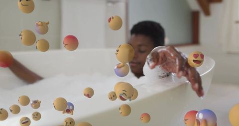 Relaxing in bubble bath with floating emoji overlays, home self-care concept