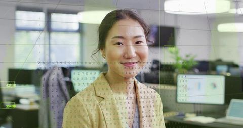 Smiling businesswoman in open-plan office with data visualization overlay and monitors