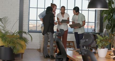 Diverse Team Collaborating in Modern Office with Digital Tablets