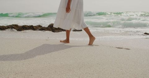 Woman Walking Barefoot on Sunny Beach with Waves and Rocks - Download Free Stock Images Pikwizard.com