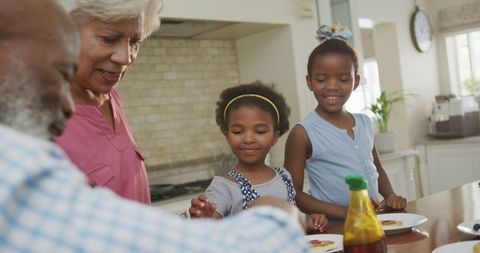 Happy Grandparents and Kids Sharing Breakfast in Kitchen