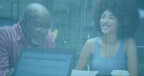 Senior Colleague Mentoring Junior at Modern Office Workspace