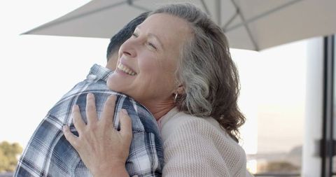 Mature Couple Embracing on Balcony with Scenic View