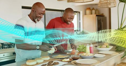 Father and son preparing homemade burgers at kitchen island, smiling and cooking together