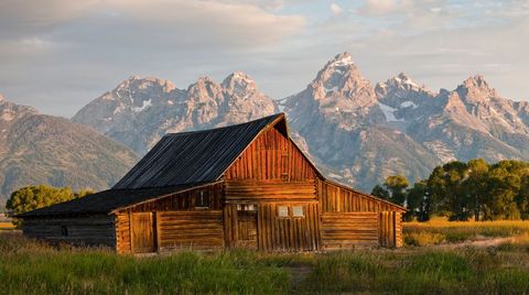 Rustic Barn Glowing at Golden Hour with Mountain Range Backdrop