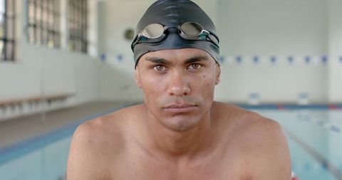 Focused male swimmer in pool with determined expression