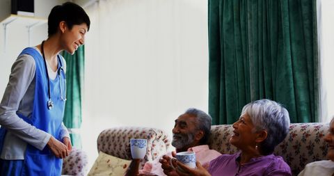 Doctor serving coffee to seniors in nursing home