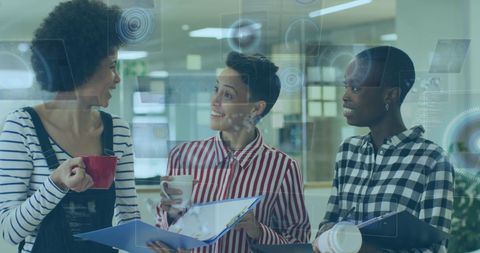 Diverse female colleagues utilizing technology during coffee break