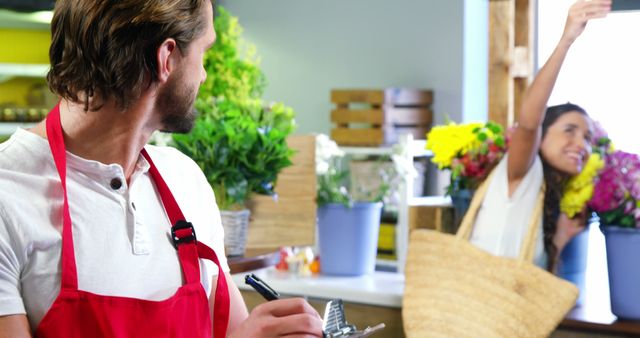 Florist Interacting with Happy Woman Buying Flowers in Shop - Download Free Stock Images Pikwizard.com