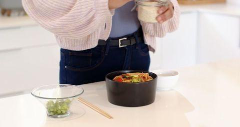 Woman Preparing Asian Noodles in Modern Kitchen