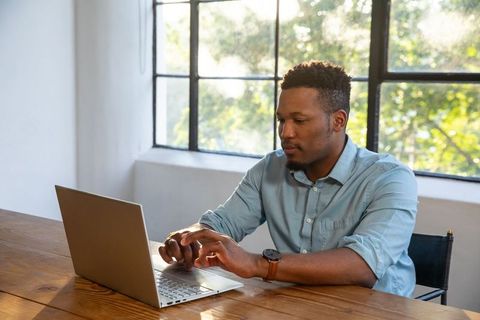 Man Typing on Laptop in Bright Modern Office Setting