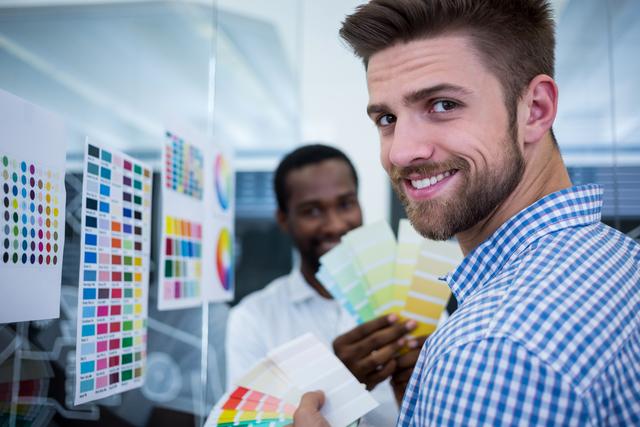 Male Graphic Designers Holding Color Swatches in Office - Download Free Stock Photos Pikwizard.com